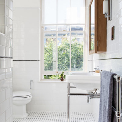 Ornate subway tile and black and white tile bathroom photo in London with a console sink, a two-piece toilet and white walls