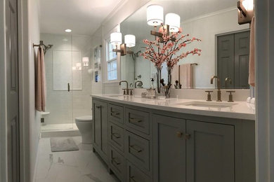 シャーロットにある広いおしゃれな浴室 (グレーのキャビネット、白い壁、白い床、開き戸のシャワー、白い洗面カウンター、シャワーベンチ、洗面台2つ、造り付け洗面台) の写真