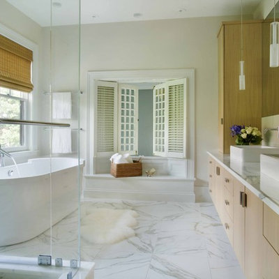 Trendy freestanding bathtub photo in Boston with marble countertops and a vessel sink