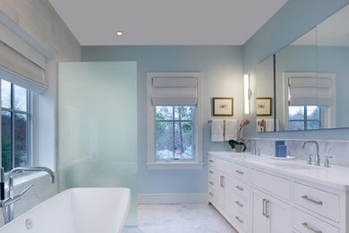 ニューヨークにあるお手頃価格の中くらいなトラディショナルスタイルのおしゃれなマスターバスルーム (一体型シンク、シェーカースタイル扉のキャビネット、白いキャビネット、大理石の洗面台、置き型浴槽、コーナー設置型シャワー、分離型トイレ、白いタイル、石タイル、青い壁、大理石の床) の写真