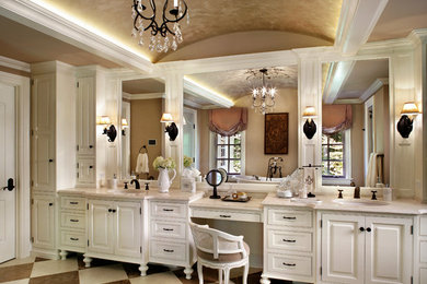 Example of a large classic limestone floor alcove shower design in New York with an undermount sink, white cabinets, beige walls, limestone countertops and raised-panel cabinets