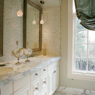 Example of a classic beige tile and ceramic tile bathroom design in Portland with an undermount sink, raised-panel cabinets, white cabinets and marble countertops