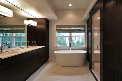 ワシントンD.C.にある広いコンテンポラリースタイルのおしゃれなマスターバスルーム (濃色木目調キャビネット、置き型浴槽、ベージュの壁、セラミックタイルの床) の写真
