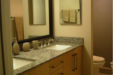 マイアミにあるコンテンポラリースタイルのおしゃれな浴室 (アンダーカウンター洗面器、フラットパネル扉のキャビネット、中間色木目調キャビネット、珪岩の洗面台、アルコーブ型シャワー、一体型トイレ	、茶色いタイル、セラミックタイル、ベージュの壁、セラミックタイルの床) の写真