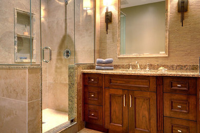 Example of a large transitional master brown tile and porcelain tile porcelain tile and beige floor corner shower design in Toronto with recessed-panel cabinets, dark wood cabinets, brown walls, an undermount sink, granite countertops and a hinged shower door