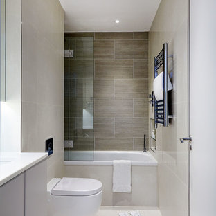Idee per una stanza da bagno padronale minimal con ante lisce, vasca da incasso, WC sospeso, piastrelle beige, piastrelle in ceramica, pareti beige, pavimento con piastrelle in ceramica, lavabo sottopiano e top in superficie solida