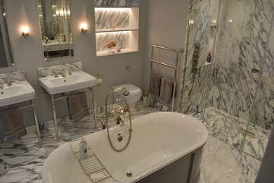 Photo of a traditional ensuite bathroom in Other with a freestanding bath, a walk-in shower, white tiles, marble tiles, grey walls, marble flooring, a pedestal sink, marble worktops, white floors and a hinged door.