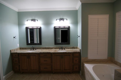 ニューオリンズにあるおしゃれな浴室 (中間色木目調キャビネット、アンダーカウンター洗面器、開き戸のシャワー) の写真