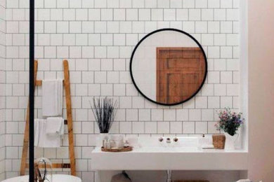 Modelo de cuarto de baño contemporáneo con bañera exenta, baldosas y/o azulejos blancos, suelo gris y encimeras blancas