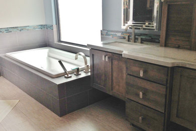 Photo of a medium sized contemporary ensuite bathroom in Phoenix with flat-panel cabinets, dark wood cabinets, an alcove bath, beige tiles, stone tiles, white walls, travertine flooring, a submerged sink, granite worktops and beige floors.