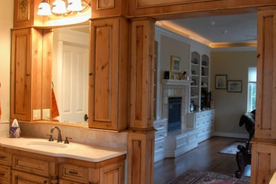 Example of a large mountain style master travertine floor and beige floor bathroom design in Other with raised-panel cabinets, light wood cabinets, beige walls, an undermount sink and quartz countertops