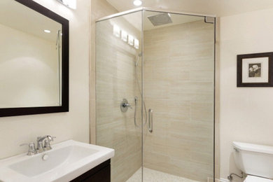 Corner shower - small contemporary 3/4 beige tile and stone tile corner shower idea in San Francisco with an undermount sink, dark wood cabinets, a one-piece toilet, beige walls, quartz countertops, a hinged shower door and white countertops