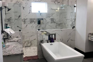 Large traditional ensuite bathroom in New Orleans with a freestanding bath, an alcove shower, grey tiles, marble tiles, grey walls, concrete flooring, a submerged sink, granite worktops, grey floors, an open shower, grey worktops and a single sink.