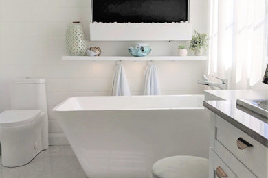 Master white tile and marble tile porcelain tile and gray floor bathroom photo in Other with shaker cabinets, white cabinets, a one-piece toilet, a drop-in sink, quartz countertops and gray countertops