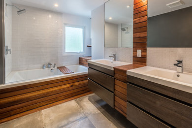 Ejemplo de cuarto de baño contemporáneo con armarios con paneles lisos, puertas de armario de madera en tonos medios, bañera empotrada, ducha empotrada, baldosas y/o azulejos blancos, paredes blancas, lavabo integrado y ducha abierta