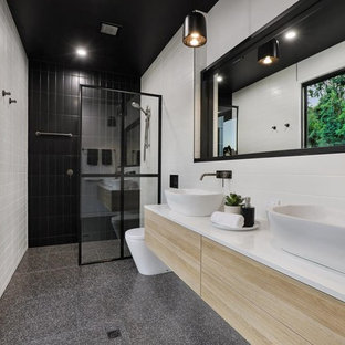 Design ideas for a contemporary bathroom in Sunshine Coast with flat-panel cabinets, light wood cabinets, a curbless shower, white tile, white walls, a vessel sink, grey floor, an open shower and white benchtops.