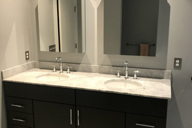 Example of a mid-century modern master bathroom design in Providence with flat-panel cabinets, dark wood cabinets and marble countertops