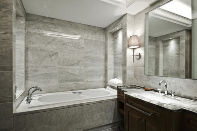 Example of a mid-sized ornate master gray tile and stone tile marble floor double shower design in Other with an undermount sink, furniture-like cabinets, brown cabinets, marble countertops, an undermount tub, a one-piece toilet and gray walls
