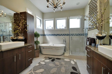 Example of a mid-sized trendy master gray tile and ceramic tile ceramic tile bathroom design in Houston with a vessel sink, flat-panel cabinets, medium tone wood cabinets, granite countertops and beige walls