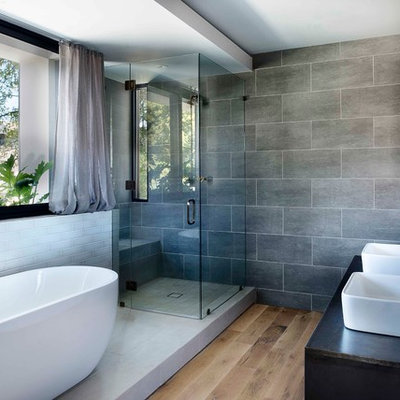Inspiration for an industrial master gray tile light wood floor bathroom remodel in Atlanta with a vessel sink and a hinged shower door