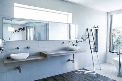 Freestanding bathtub - huge modern master gray tile and pebble tile porcelain tile freestanding bathtub idea in Orange County with white walls, open cabinets and a vessel sink
