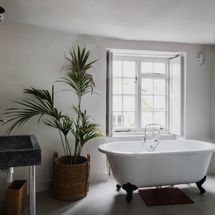 Design ideas for a medium sized traditional ensuite bathroom in London with a claw-foot bath, grey walls, grey floors and a wall-mounted sink.