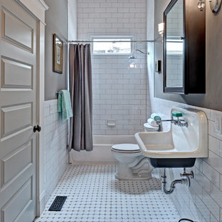 Modelo de cuarto de baño clásico, de tamaño medio, con lavabo suspendido, baldosas y/o azulejos blancos, baldosas y/o azulejos de cemento, paredes grises, suelo de baldosas de cerámica, bañera empotrada y combinación de ducha y bañera