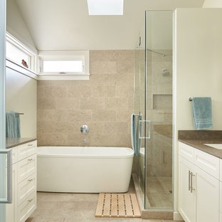 Immagine di una stanza da bagno padronale minimalista di medie dimensioni con lavabo sottopiano, ante con riquadro incassato, ante bianche, top in pietra calcarea, vasca freestanding, doccia ad angolo, WC monopezzo, piastrelle grigie, lastra di pietra, pareti bianche e pavimento in pietra calcarea