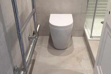 Inspiration pour une petite salle d'eau design avec un placard à porte plane, des portes de placard blanches, une douche à l'italienne, WC à poser, un carrelage gris, des carreaux de céramique, un mur gris, un sol en carrelage de porcelaine, un lavabo suspendu, un plan de toilette en quartz, un sol gris, une cabine de douche à porte battante et un plan de toilette blanc.