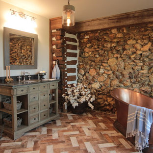 Inspiration for a mid-sized country master beige tile and porcelain tile brick floor and multicolored floor bathroom remodel in Atlanta with furniture-like cabinets, distressed cabinets, a one-piece toilet, white walls, an undermount sink, soapstone countertops and gray countertops