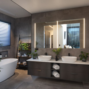 Large contemporary 3/4 bathroom in Melbourne with flat-panel cabinets, brown cabinets, a freestanding tub, gray tile, a vessel sink, grey floor, white benchtops, a niche, a double vanity and a built-in vanity.