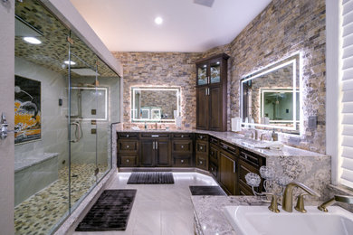Example of a large master beige tile, brown tile, gray tile and stone tile porcelain tile and white floor bathroom design in Tampa with raised-panel cabinets, dark wood cabinets, multicolored walls, an undermount sink, granite countertops, a hinged shower door and multicolored countertops