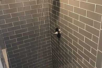 Modelo de cuarto de baño principal minimalista de tamaño medio con ducha empotrada, baldosas y/o azulejos de vidrio, suelo con mosaicos de baldosas y ducha con puerta con bisagras