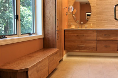 Example of a trendy beige tile and porcelain tile porcelain tile and beige floor corner shower design in Boston with flat-panel cabinets, medium tone wood cabinets, an undermount sink, quartz countertops and a hinged shower door