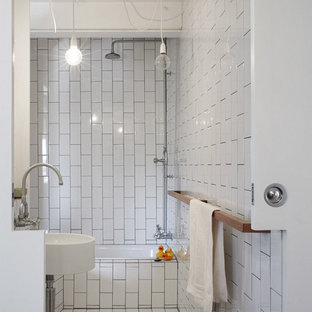 Photo of an industrial bathroom in Brisbane with an alcove tub, a shower/bathtub combo, white tile, a wall-mount sink and grey floor.