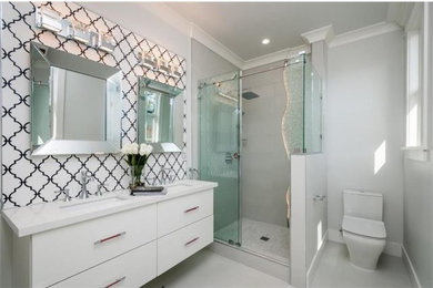 Inspiration for a mid-sized modern master black and white tile and ceramic tile porcelain tile and white floor bathroom remodel in San Francisco with flat-panel cabinets, white cabinets, a two-piece toilet, white walls, an undermount sink, solid surface countertops and white countertops