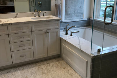 Mid-sized transitional master white tile and subway tile marble floor, white floor and double-sink corner shower photo in San Francisco with shaker cabinets, gray cabinets, an undermount tub, a two-piece toilet, white walls, an undermount sink, quartz countertops, a hinged shower door, white countertops and a built-in vanity