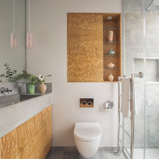 Design ideas for a contemporary shower room bathroom in London with flat-panel cabinets, brown cabinets, an alcove shower, a wall mounted toilet, grey tiles, metro tiles, white walls, an integrated sink, concrete worktops, grey floors and grey worktops.