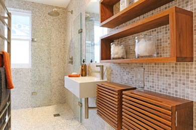Small modern shower room bathroom in London with open cabinets, dark wood cabinets, a walk-in shower, a wall mounted toilet, grey tiles, mosaic tiles, grey walls, mosaic tile flooring, a vessel sink and wooden worktops.