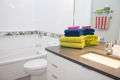 Example of a minimalist white tile bathroom design in Other with an undermount sink, flat-panel cabinets, white cabinets, quartz countertops and a two-piece toilet
