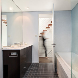 Inspiration for a mid-sized modern master bathroom in Sydney with flat-panel cabinets, dark wood cabinets, a drop-in tub, an undermount sink, white benchtops, a single vanity, a built-in vanity, an open shower, a one-piece toilet, white tile, glass tile, white walls, porcelain floors, engineered quartz benchtops, grey floor, an open shower, a niche and recessed.