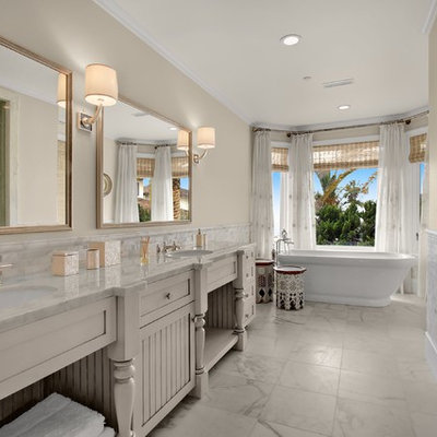 Inspiration for a mid-sized timeless master white tile and marble tile marble floor and white floor bathroom remodel in San Diego with furniture-like cabinets, white cabinets, beige walls, an undermount sink, marble countertops, a hinged shower door, a two-piece toilet and white countertops
