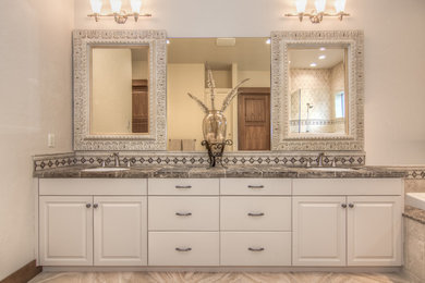 Imagen de cuarto de baño principal rural de tamaño medio con puertas de armario blancas, baldosas y/o azulejos beige, lavabo bajoencimera, encimera de azulejos, paredes blancas y armarios con paneles empotrados