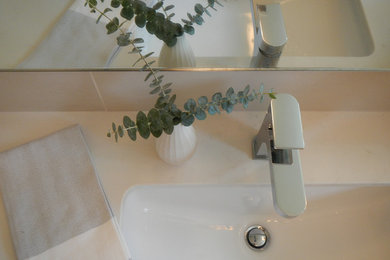 サンフランシスコにある高級な中くらいなモダンスタイルのおしゃれなバスルーム (浴槽なし) (アンダーカウンター洗面器、フラットパネル扉のキャビネット、中間色木目調キャビネット、クオーツストーンの洗面台、一体型トイレ	、白いタイル、セラミックタイル、白い壁、セラミックタイルの床) の写真