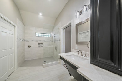 Mid-sized trendy master gray tile and ceramic tile ceramic tile, gray floor, tray ceiling and double-sink bathroom photo in Houston with raised-panel cabinets, white cabinets, a bidet, gray walls, an undermount sink, quartz countertops, white countertops, a niche and a built-in vanity