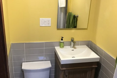 Design ideas for a small contemporary bathroom in Boston with freestanding cabinets, distressed cabinets, a walk-in shower, a one-piece toilet, yellow tiles, metro tiles, yellow walls, ceramic flooring, a built-in sink, multi-coloured floors and a shower curtain.