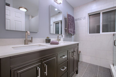Foto på ett mellanstort funkis badrum med dusch, med luckor med infälld panel, grå skåp, en dusch i en alkov, beige kakel, keramikplattor, grå väggar, klinkergolv i porslin, ett undermonterad handfat, bänkskiva i kvartsit, grått golv och dusch med gångjärnsdörr