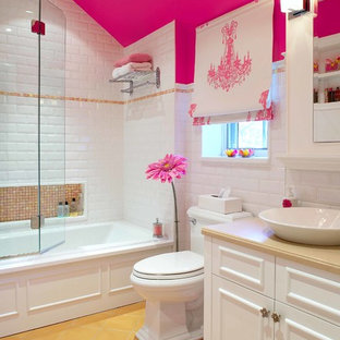 This is an example of a traditional kids bathroom in Montreal with a vessel sink, recessed-panel cabinets, white cabinets, an alcove tub, a shower/bathtub combo, a two-piece toilet, white tile, subway tile, pink walls and yellow floor.