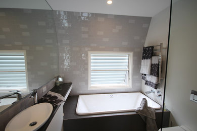 Diseño de cuarto de baño moderno con baldosas y/o azulejos grises, baldosas y/o azulejos de cerámica, paredes grises y suelo de baldosas de porcelana