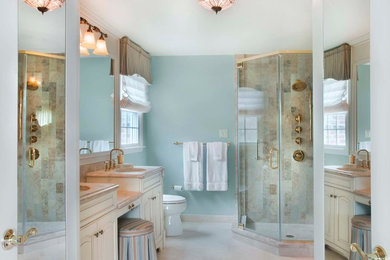 Example of a large transitional master beige tile and stone tile marble floor alcove shower design in Philadelphia with recessed-panel cabinets, white cabinets, a two-piece toilet, blue walls, an undermount sink and marble countertops